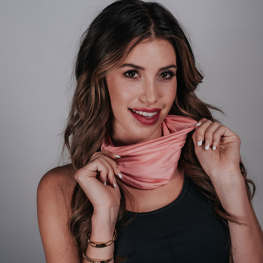 Pink CoQau Casanova neck gaiter worn around the neck with hidden elastic loops to pull up as a mask when needed. Antimicrobial, Anti-aging and Aromatherapy smart fabric that repels germs and bacteria. Sustainable Modal fabric. Washable. Breathable. Comfortable mask